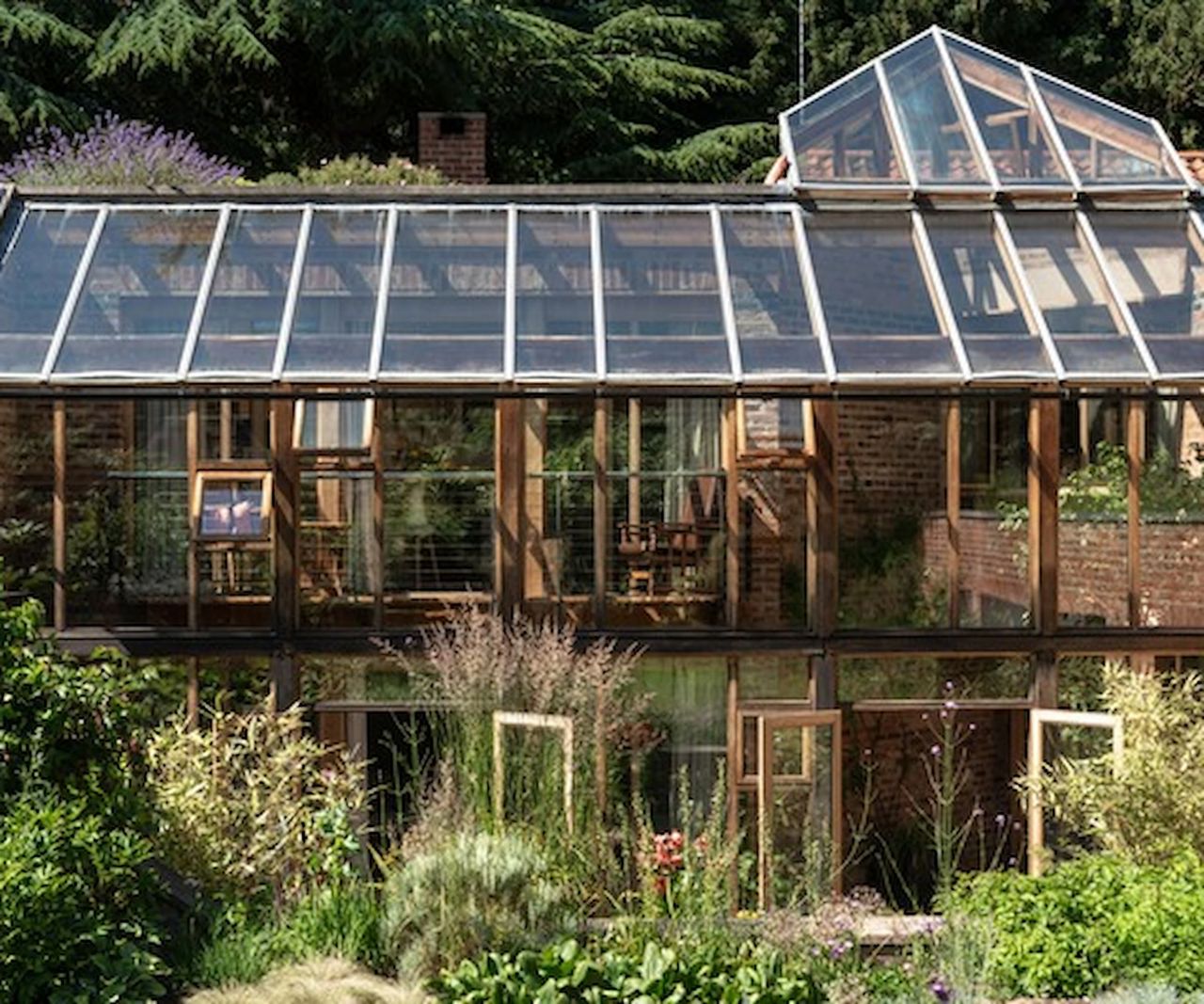 A two-tier conservatory surrounded by plants