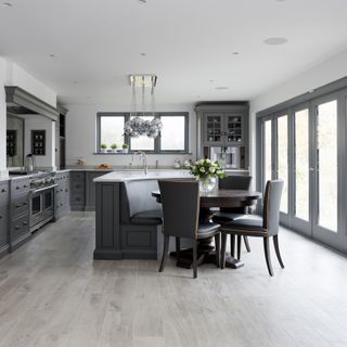 A dark grey Humphrey Munson kitchen island with low level banquette seating