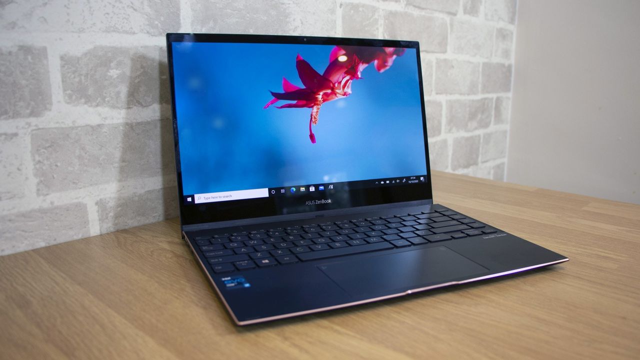 The Asus Flip S UX371 on a wooden desk with brick wall in background