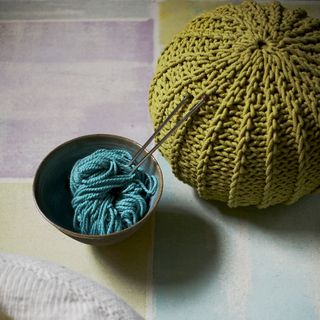 yellow coloured crochet ball yarn with knitting needles