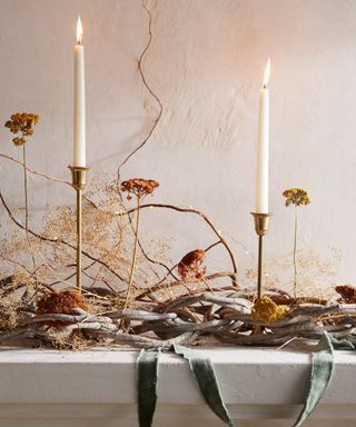 fall mantel decor with twisted twigs and foliage with ribbons and candlesticks