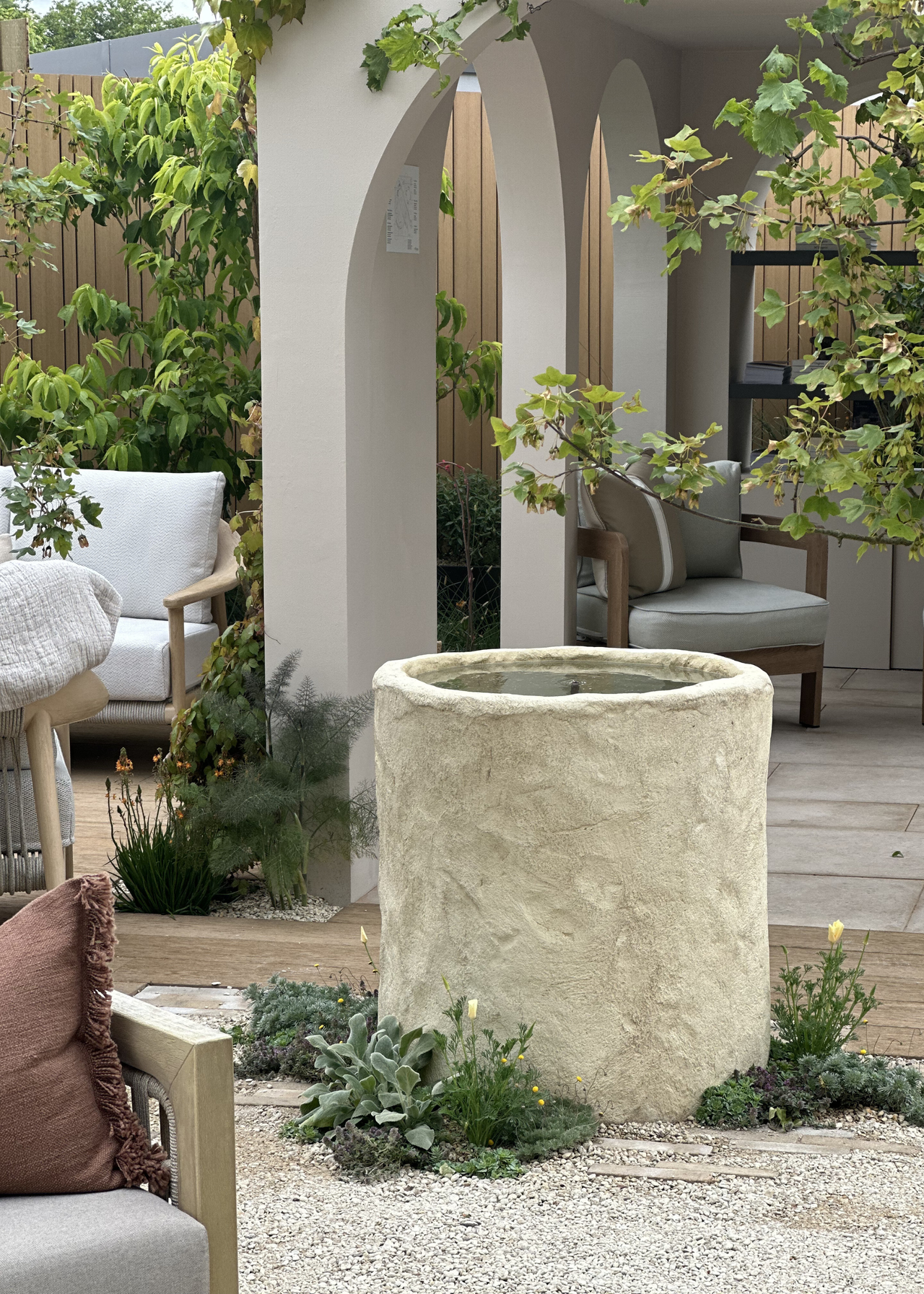 A textured planter water feature in the middle of an outdoor living room