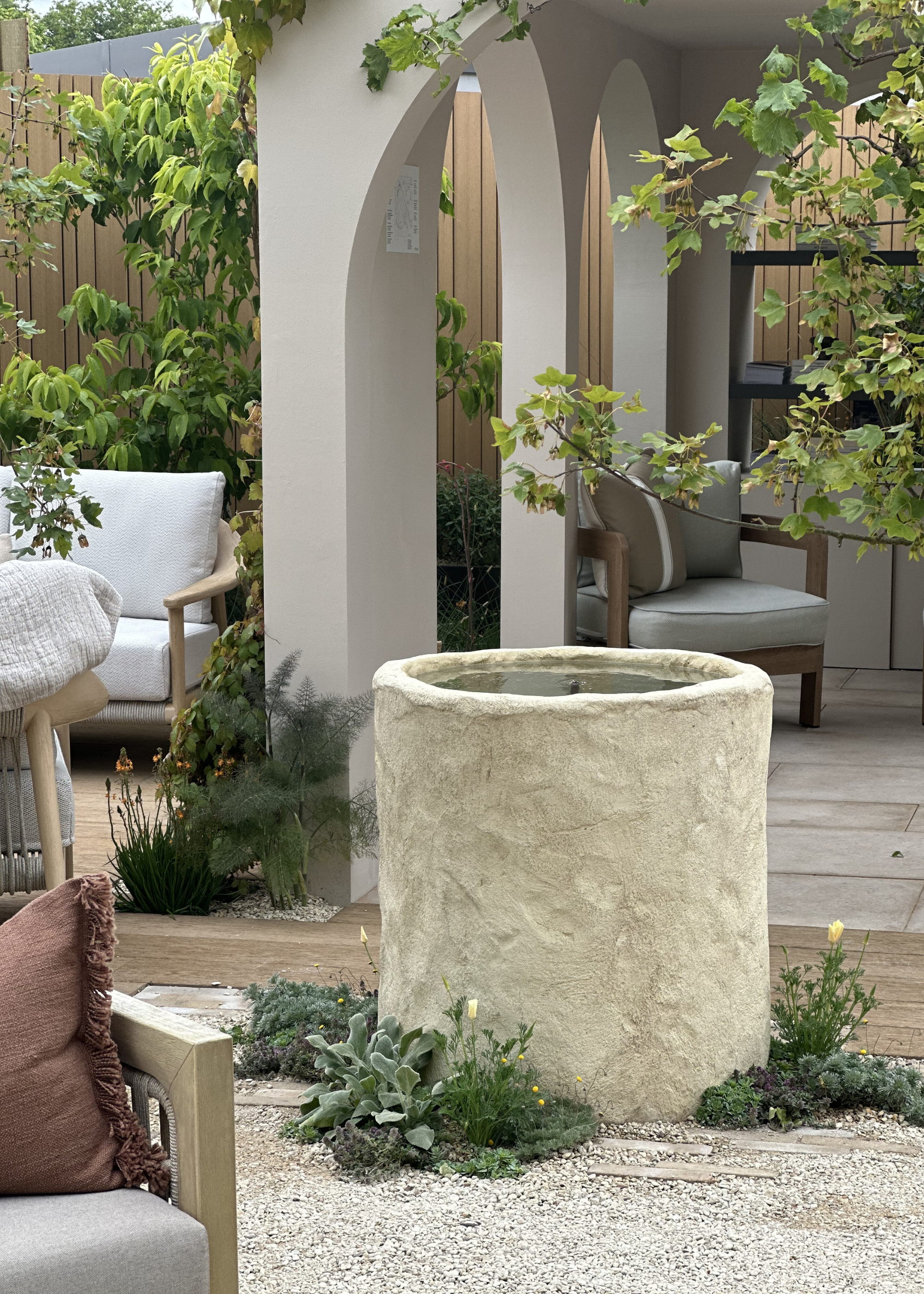 A textured planter water feature in the middle of an outdoor living room
