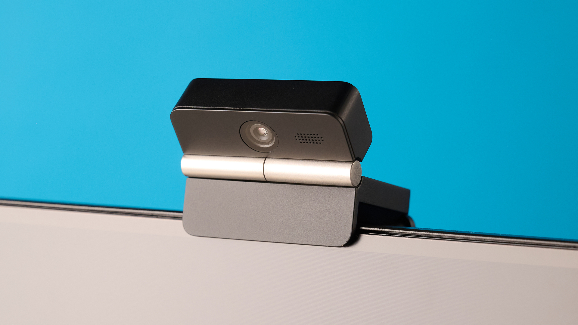 Obsbot Meet Flip foldable webcam photographed in front of a blue background