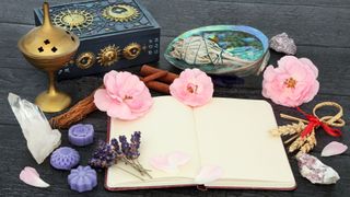 Crystal healing for fertility problems with recipe notebook, corn dolly, crystals, rose flowers herbs and purification equipment. Mystical, alternative, shamanic and Wiccan concept.