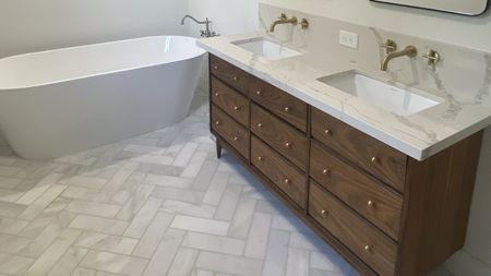 A modern bathroom with dresser vanity unit and bathtub