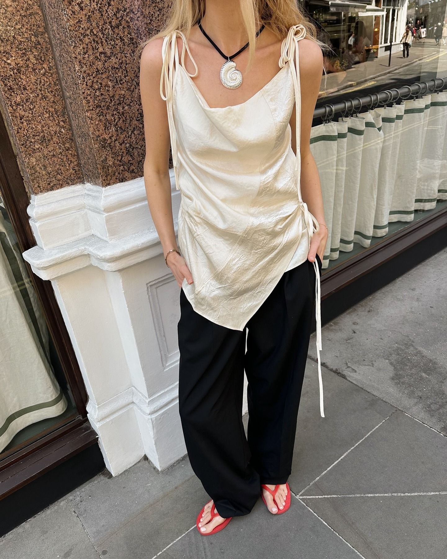 Influencer Chloe wearing a white silk cowl neck top and black trousers.