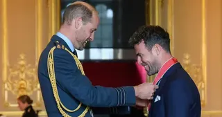 Prince William awarding Sir Mark Cavendish his knighthood in the investiture room at Buckingham Palace