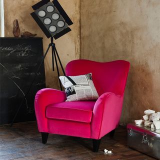 bedroom corner with pink chair and wooden flooring