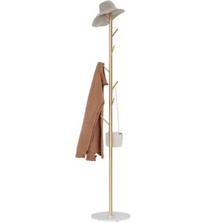 A white and gold coat rack with a coat on it