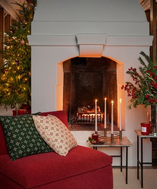 Cozy Christmas fireplace detail with candlelight and warm red colors