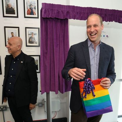 Britain's Prince William, Duke of Cambridge, reacts to receiving a gift bag from trust chief executive officer Tim Sigsworth during a visit to the Albert Kennedy Trust in London to learn about the issue of LGBTQ youth homelessness in London on June 26, 2019.