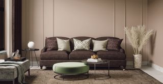 Light brown living room with upholstered brow couch round coffee table and pampas grass in a vase