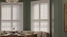 White wooden shutters from The Shutter Store in a modern, blue dining room.