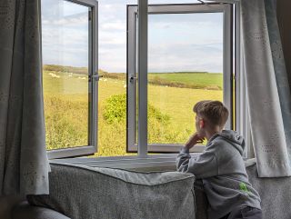 A young boy enjoying the view from Pencarrow lodge at Sandymouth Bay Holiday Resort.