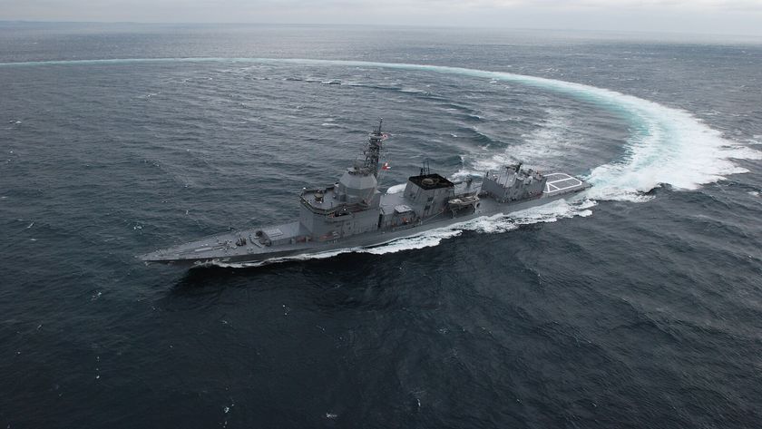Aerial photograph of Japanese ship, JS Asuka, performing a turning maneuver in the ocean. 