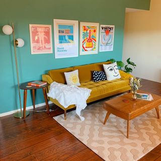 Bright turquoise living room with coffee table and yellow couch