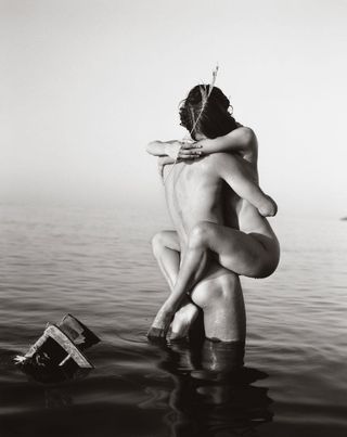 black and white photograph nude pair of bodies hugging in water