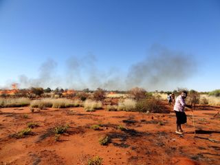 aboriginal hunters in an Australian desert cooking sand monitor lizards.