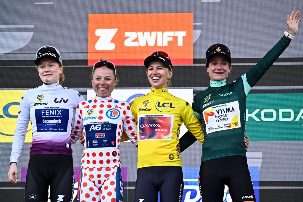 (From L) Fenix-Deceuninck team's Dutch rider Puck Pieterse wearing the best young rider's white jersey, AG Insurance - Soudal Team's Belgian rider Justine Ghekiere wearing the climber's polka dot (dotted) jersey, Overalll leader and first placed Canyon//SRAM Racing team's Polish rider Katarzyna Niewiadoma wearing the overall leader's yellow jersey and Team Visma | Lease a Bike's Dutch rider Marianne Vos wearing the best sprinter's green jersey celebrates on the podium after competing in the 8th and last stage of the third edition of the Women's Tour de France cycling race, a 149.9 km between Le Grand Bornand and the Alpe d'Huez, in L'Alpe d'Huez, south-eastern France, on August 18, 2024. (Photo by JULIEN DE ROSA / AFP)