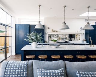 Modern kitchen ideas in blue and white, with a long breakfast bar and pendant lighting.