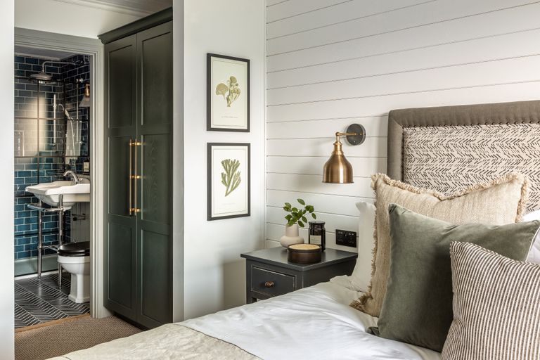 white bedroom with shiplap wall and ensuite bathroom