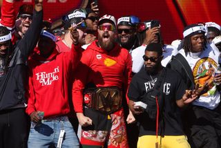 Travis Kelce celebrates on stage with teammates during the Kansas City Chiefs Super Bowl LVIII victory parade on February 14, 2024 in Kansas City, Missouri.