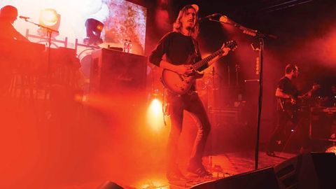 Opeth's Mikael Akerfeldt on stage bathed in orange light