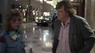 Michael Moore in a white shirt and jacket in Roger And Me.