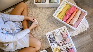 how to declutter clothes, woman organizing clothing