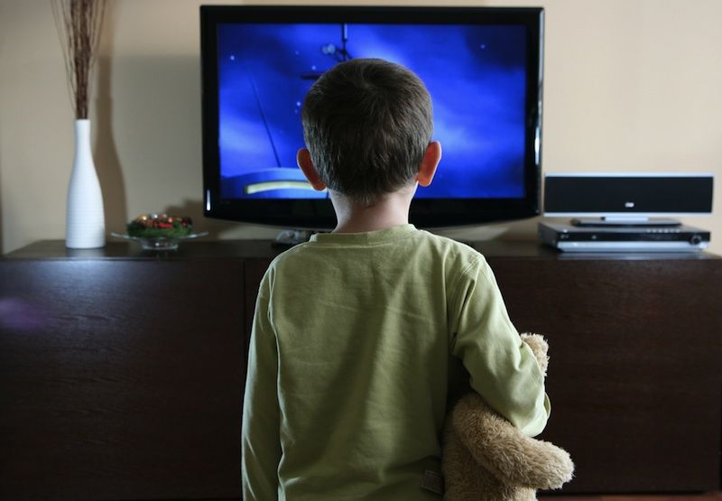 A kid watches television.