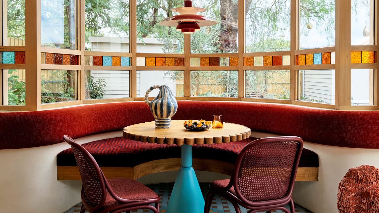 Dining nook with built-in banquette seating and window with stained glass detailing