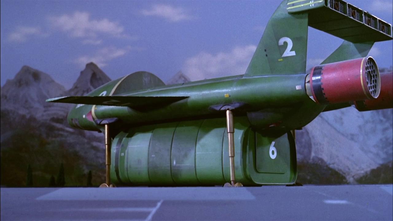 Screenshot from Thunderbirds showing Thunderbird 2 landed, with the central storage section lowered.