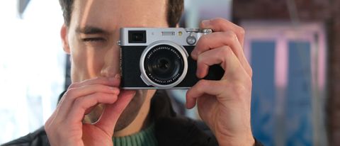 Fujifilm X100VI camera held up to a person's face