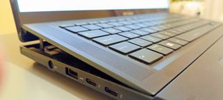 A black ASUS Zenbook Pro 16X OLED laptop on a grey table