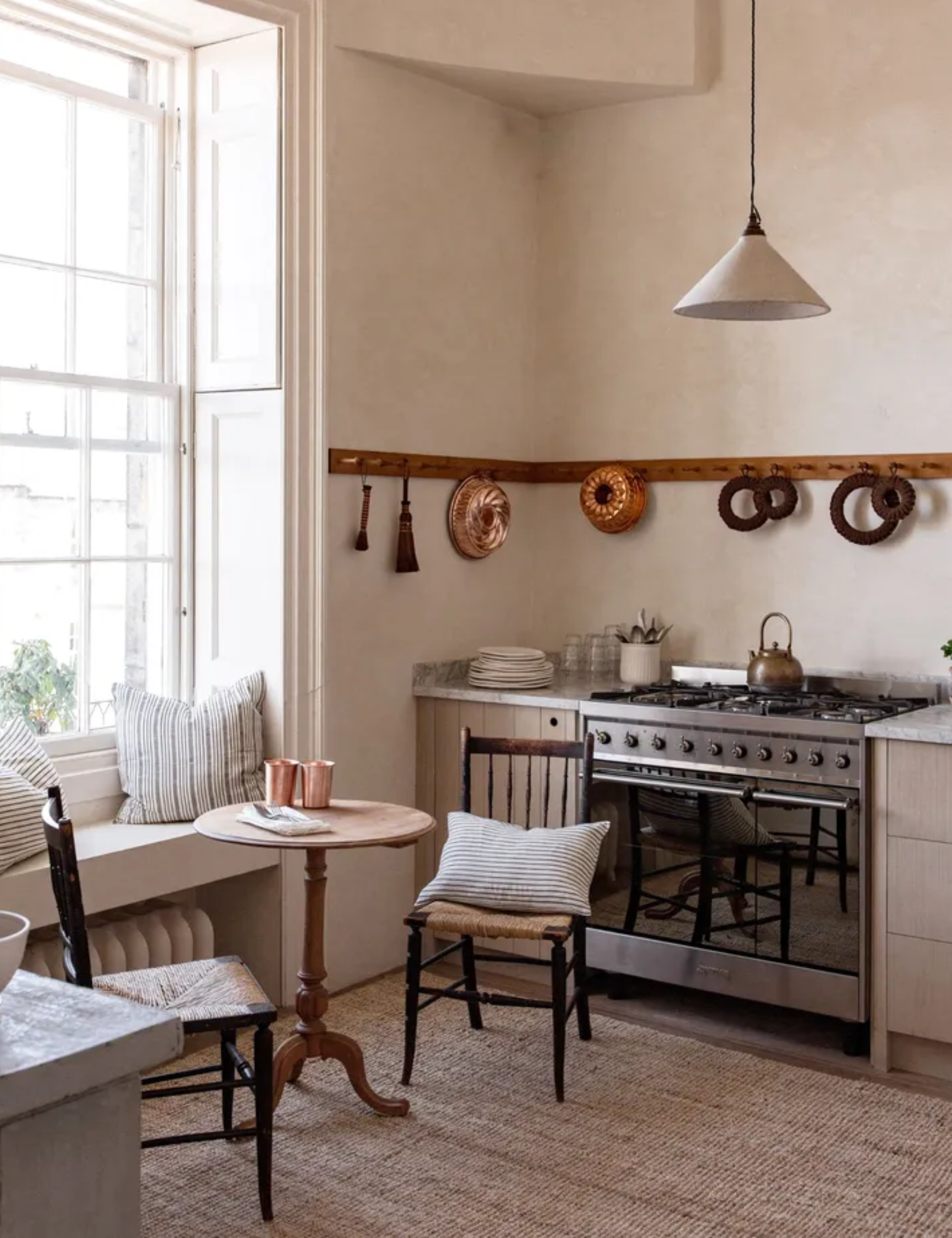 A vintage kitchen decorated with wall hooks holding antique copper molds