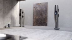 KEF Blade One Meta speakers in the grey "grigio" finish in a very light coloured room with an abstract painting between them