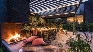 cosy outdoor seating area with outdoor fireplace and modern pergola