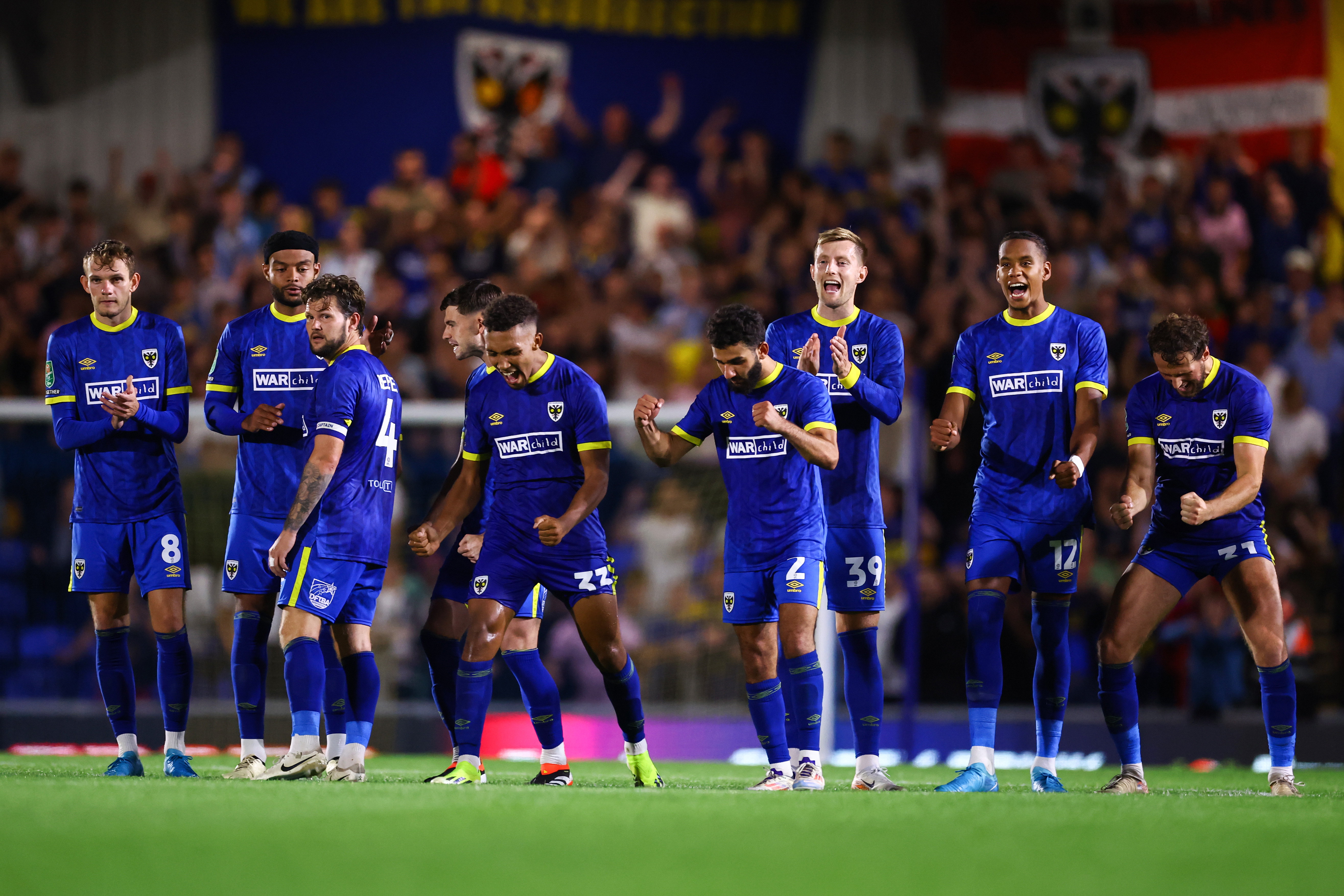 AFC Wimbledon players celebrate during the penalty shootout of their Carabao Cup tie against Ipswich Town in August 2024.