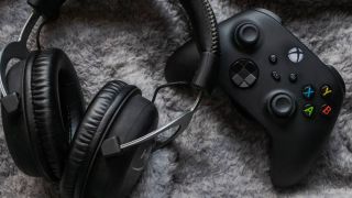 Pair of headphones next to an Xbox Series X controller