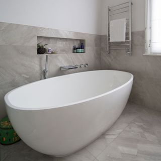 bathroom with tiled flooring and white bathtub