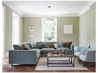 A turquoise sofa with contrasting piping in a green living room