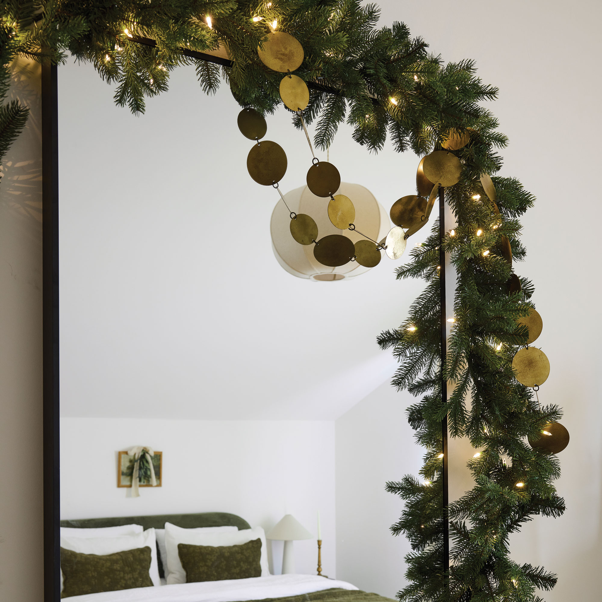 Mirror reflecting a green bed, surrounded in greenery