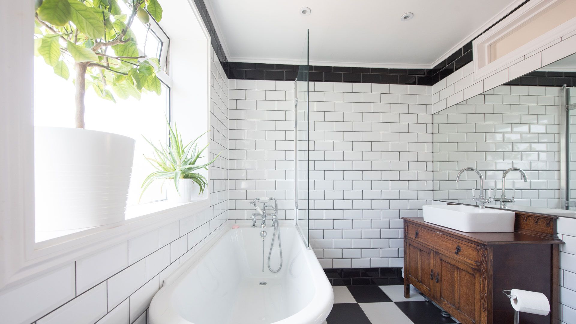 white tiled bathrom with bath and shower with window open to show how to prevent condensation on windows