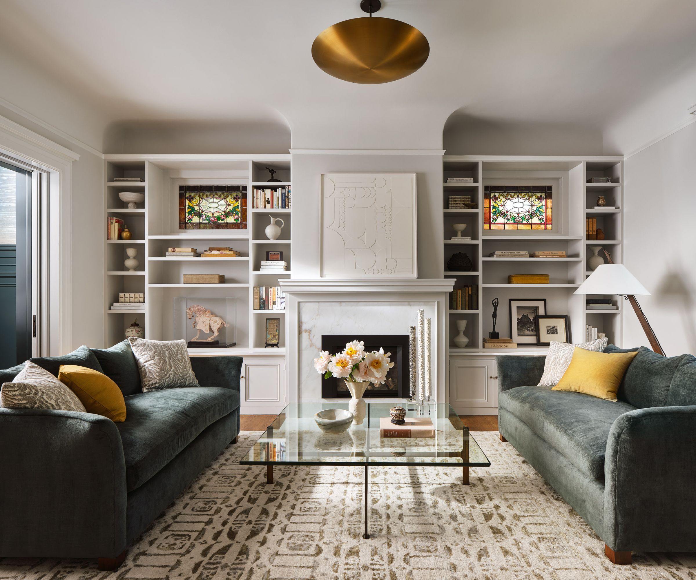 living room with green velvet sofas geometric rug