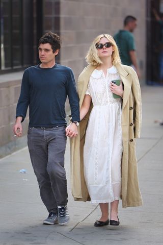 Elle Fanning walks in New York City wearing a Dôen dress and a trench coat