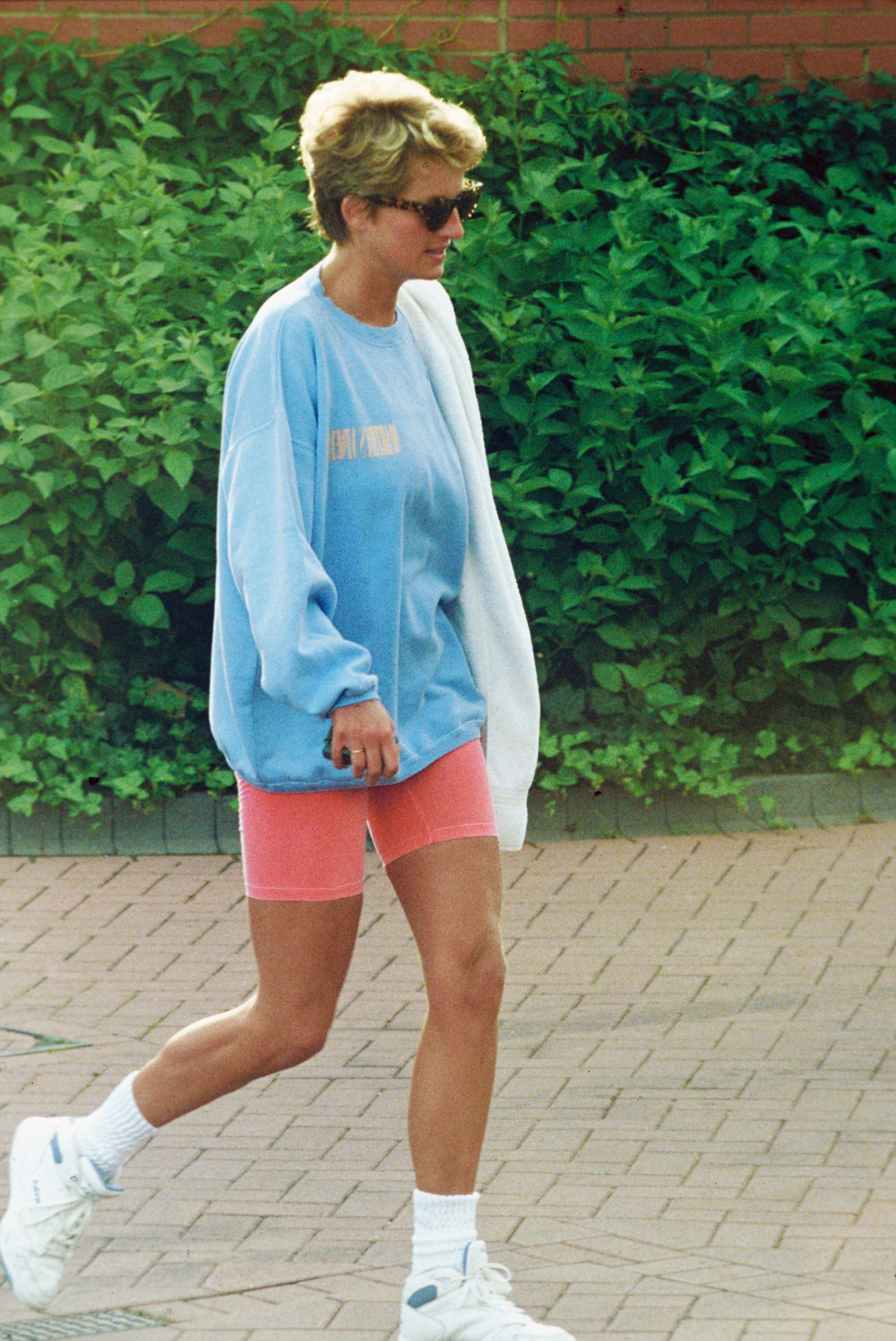 Princess Diana wearing bike shorts and a sweatshirt leaving the gym