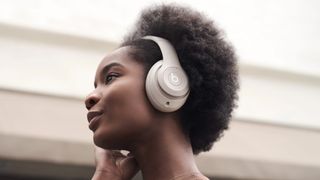Woman wearing Beats Studio Pro headphones.