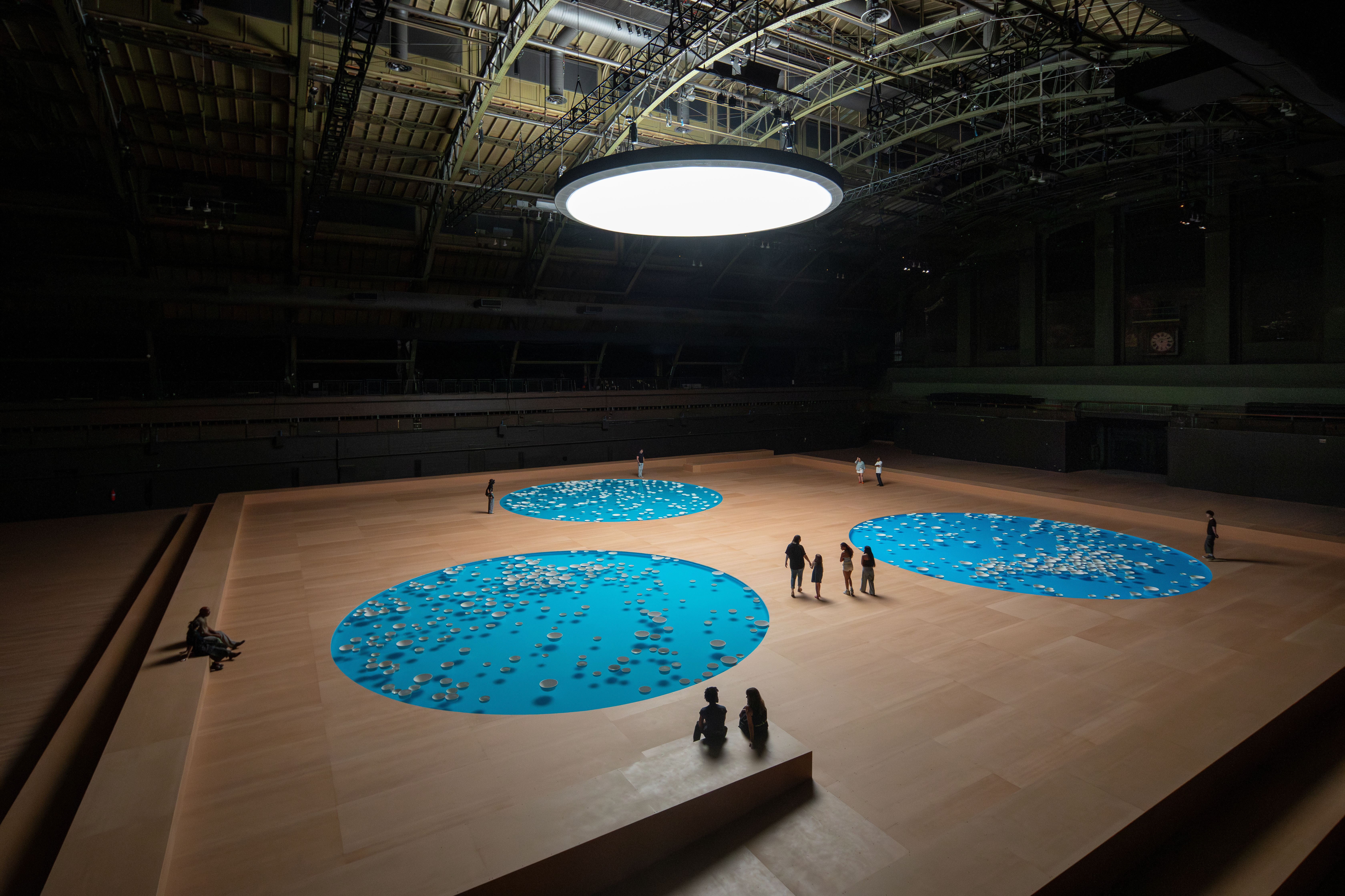 A view of 'Clinamen,' an exhibition at Park Avenue by C&amp;eacute;leste Boursier with three circular pools filled with white bowls.