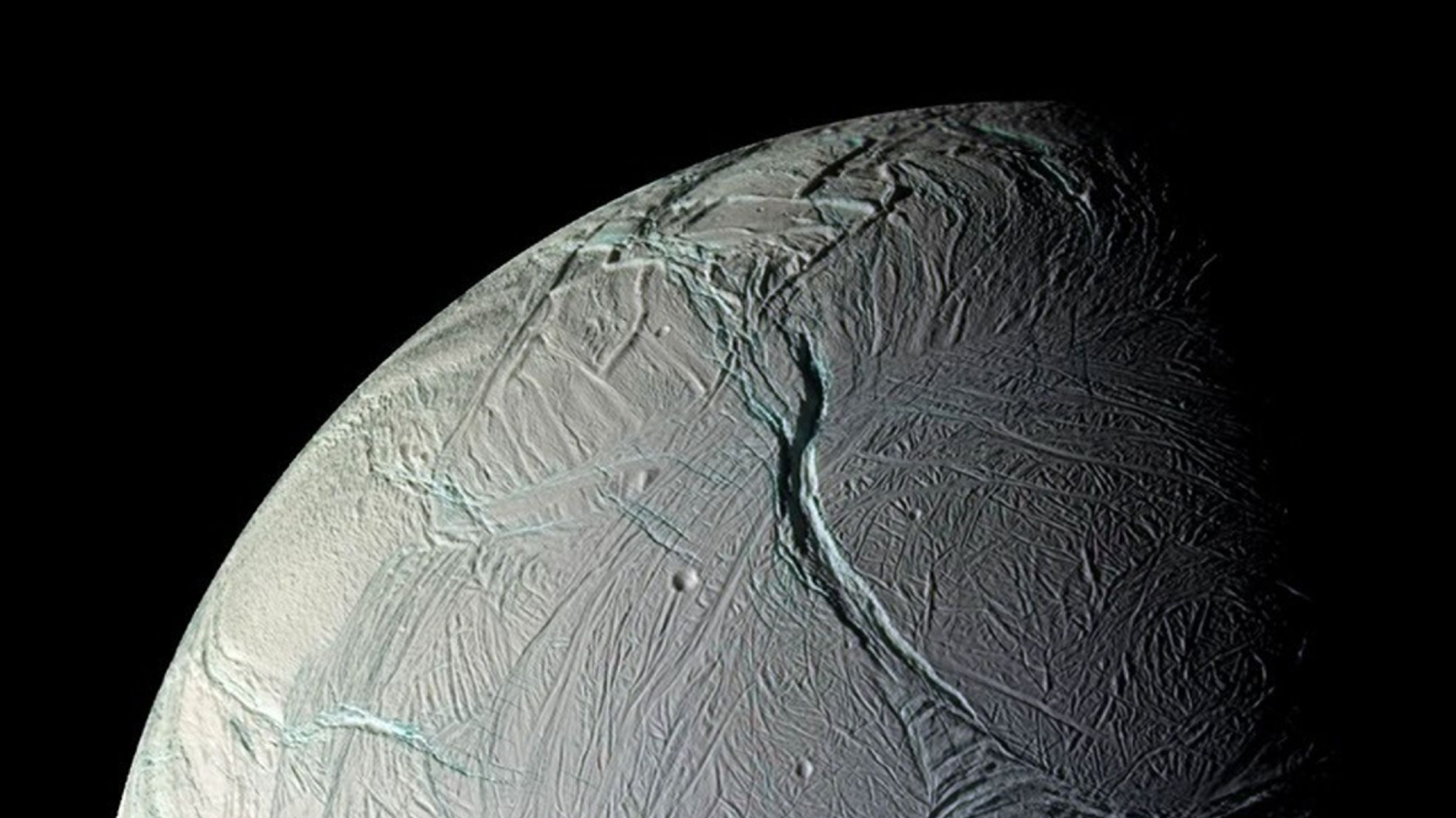 A close up of a gray planet with various streaks and ditches in its surface.